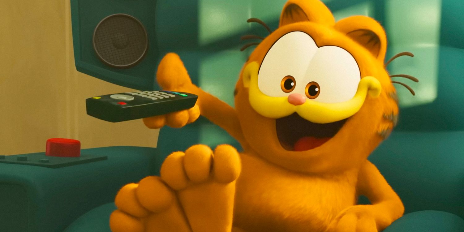 Garfield uśmiecha się i wskazuje na pilota telewizora w filmie Garfield (2024)