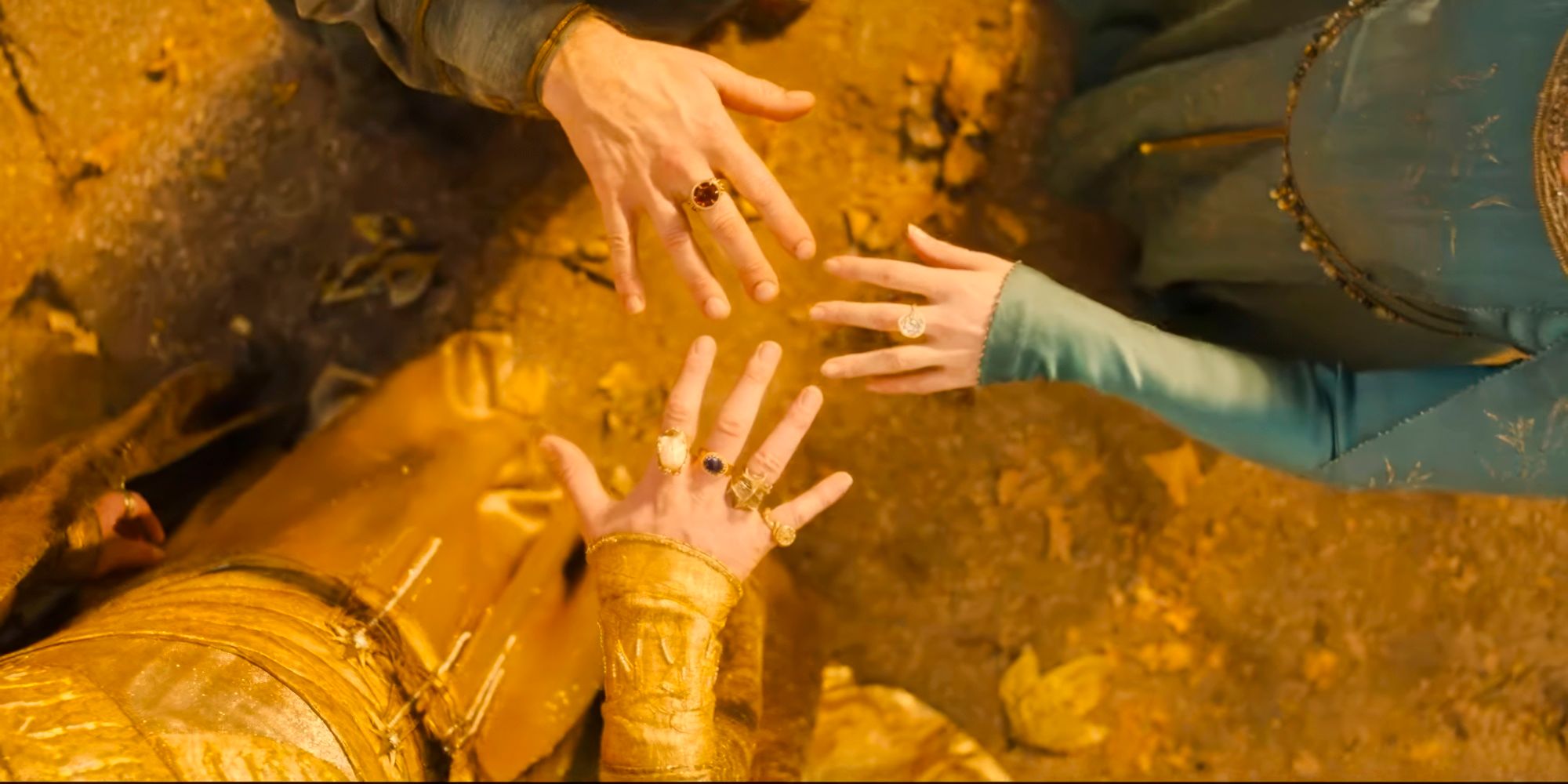Three hands showing different rings of power in The Lord of the Rings: The Rings of Power season 2