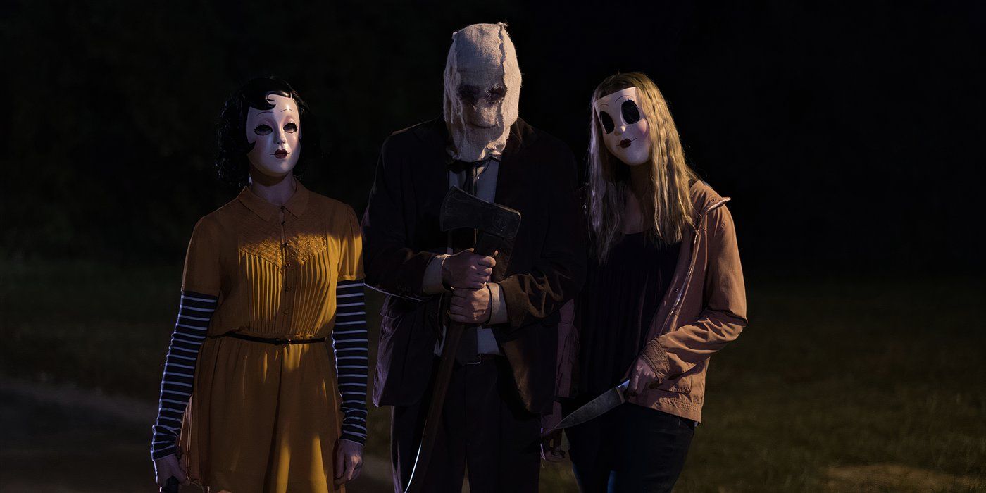 The three masked killers standing with weapons in The Strangers Prey at Night