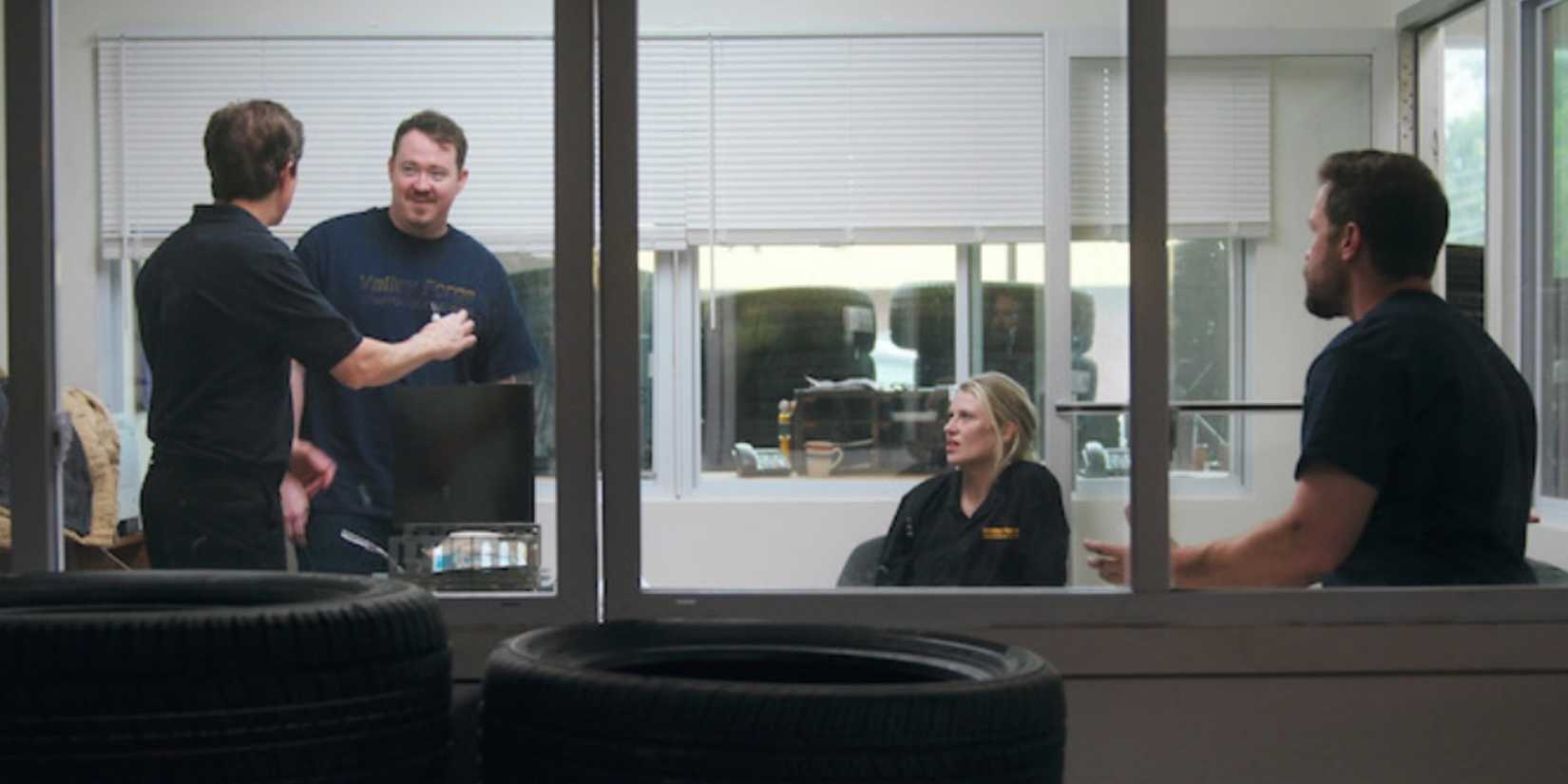 The team of Valley Forge Auto discuss strategy in a meeting as seen through the shop window in Tires