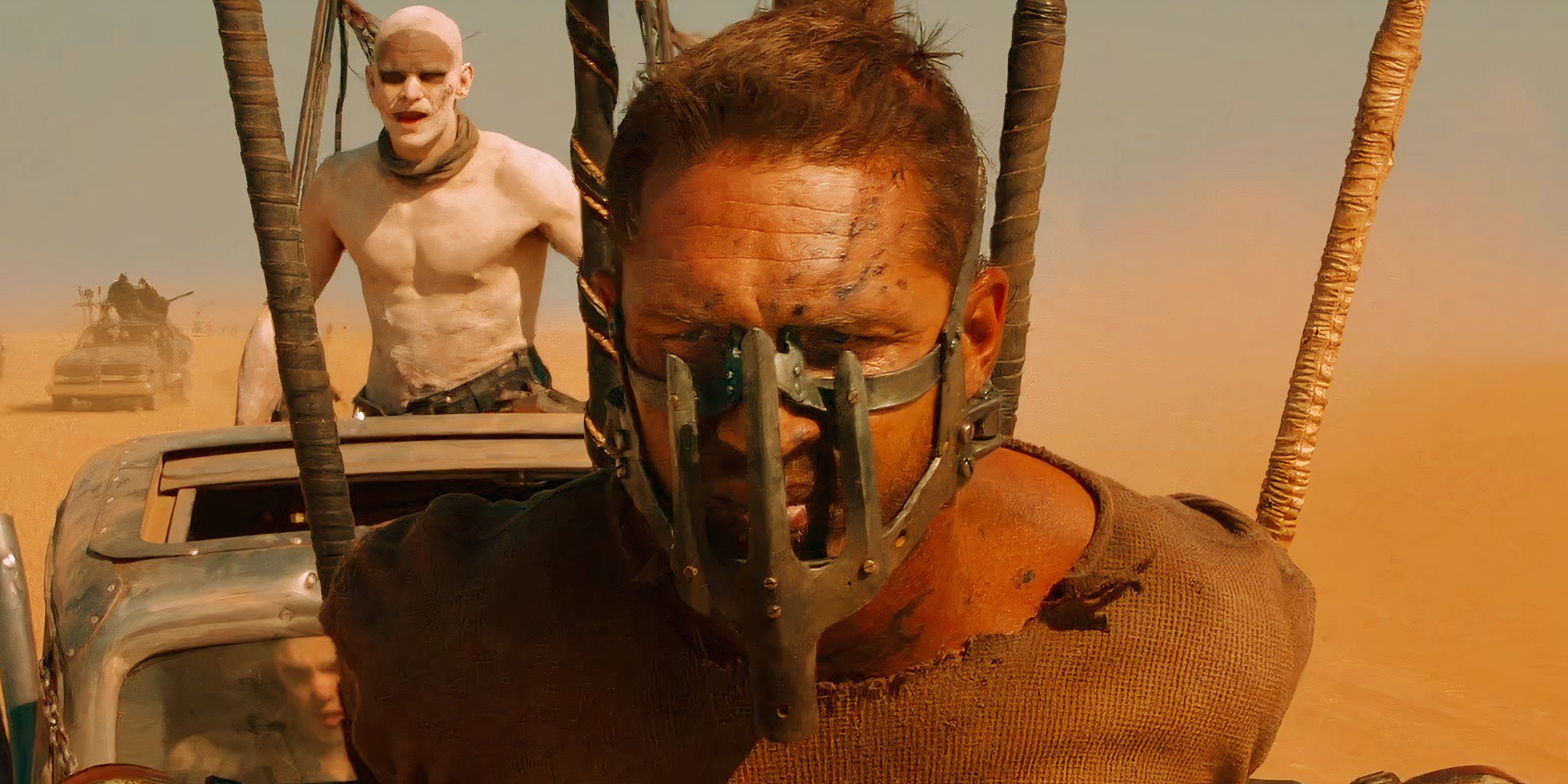 Tom Hardy sebagai Max memakai topeng dan dirantai ke mobil di Mad Max Fury Road