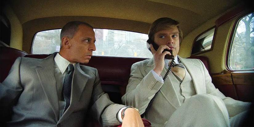Jeremy Strong as Roy Cohn staring at Sebastian Stan as Donald Trump on the phone in The Apprentice