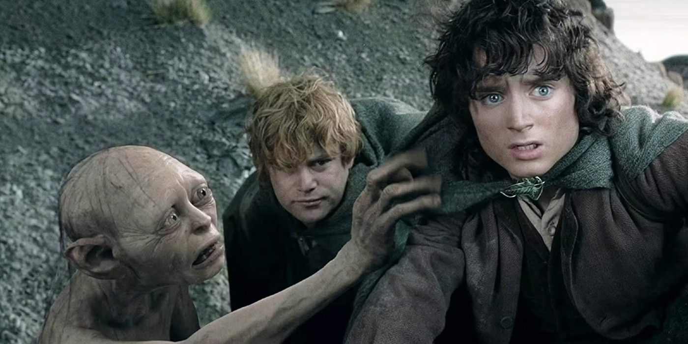Frodo, Sam, and Gollum crouched on a mountainside in Lord of the Rings