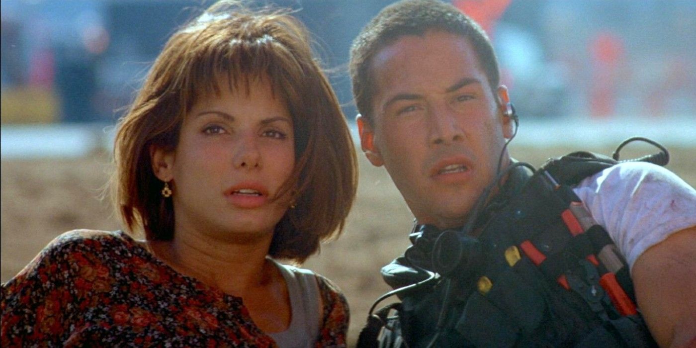 Keanu Reeves e Sandra Bullock no chão e olhando ao longe em Speed