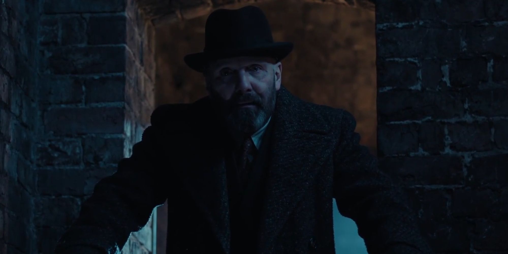 Johnny Harris standing in a doorway looking ominous as Osip Glebnikov in A Gentleman in Moscow