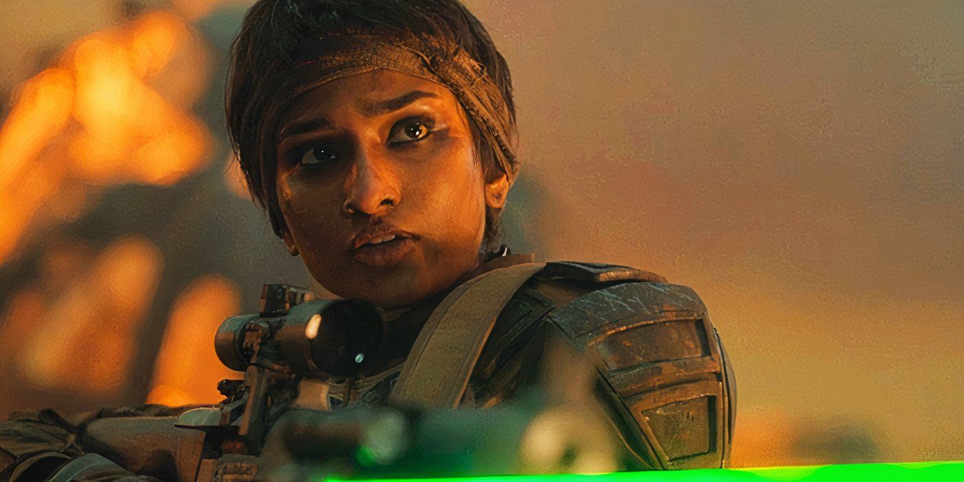 Varada Sethu as a solider pointing a gun, which has a green beam shooting from it, in Doctor Who
