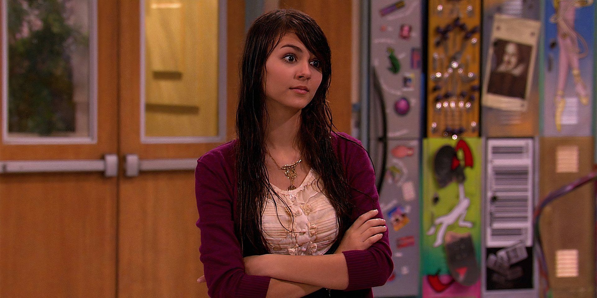 Victoria Justice as Tori standing in the hallway of her high school with  her arms crossed, looking disapproving, in Victorious