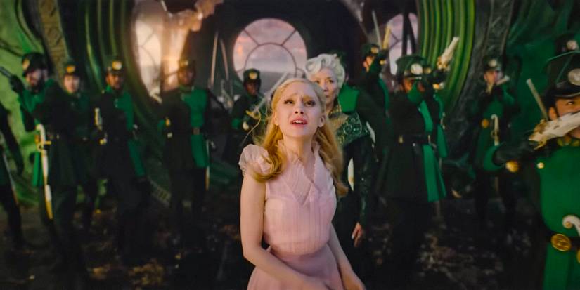Glinda (Ariana Grande) looking distressed with Madame Morrible (Michelle Yeoh) behind her in Wicked 