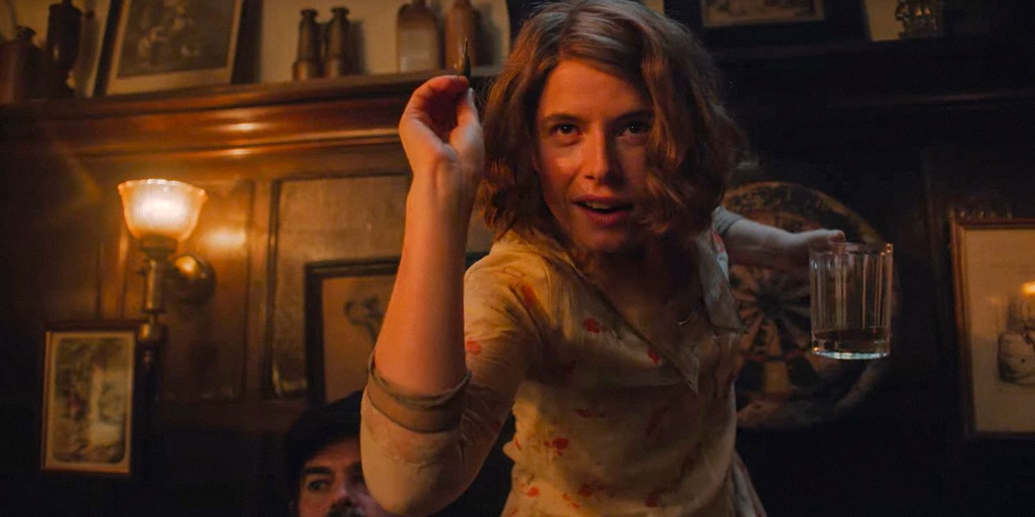 Rose (Jessie Buckley) segura sua cerveja enquanto tenta lançar um dardo em Wicked Little Letters