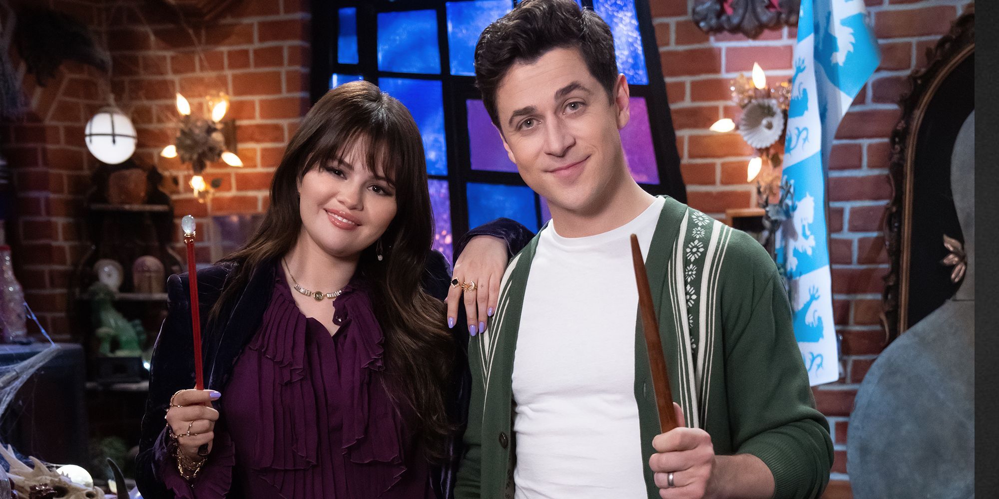 Selena Gomez and David Henrie standing together holding wands, while Gomez has her arm on Henrie's shoulder, on the Wizard Liar set from Wizards of Waverly Place