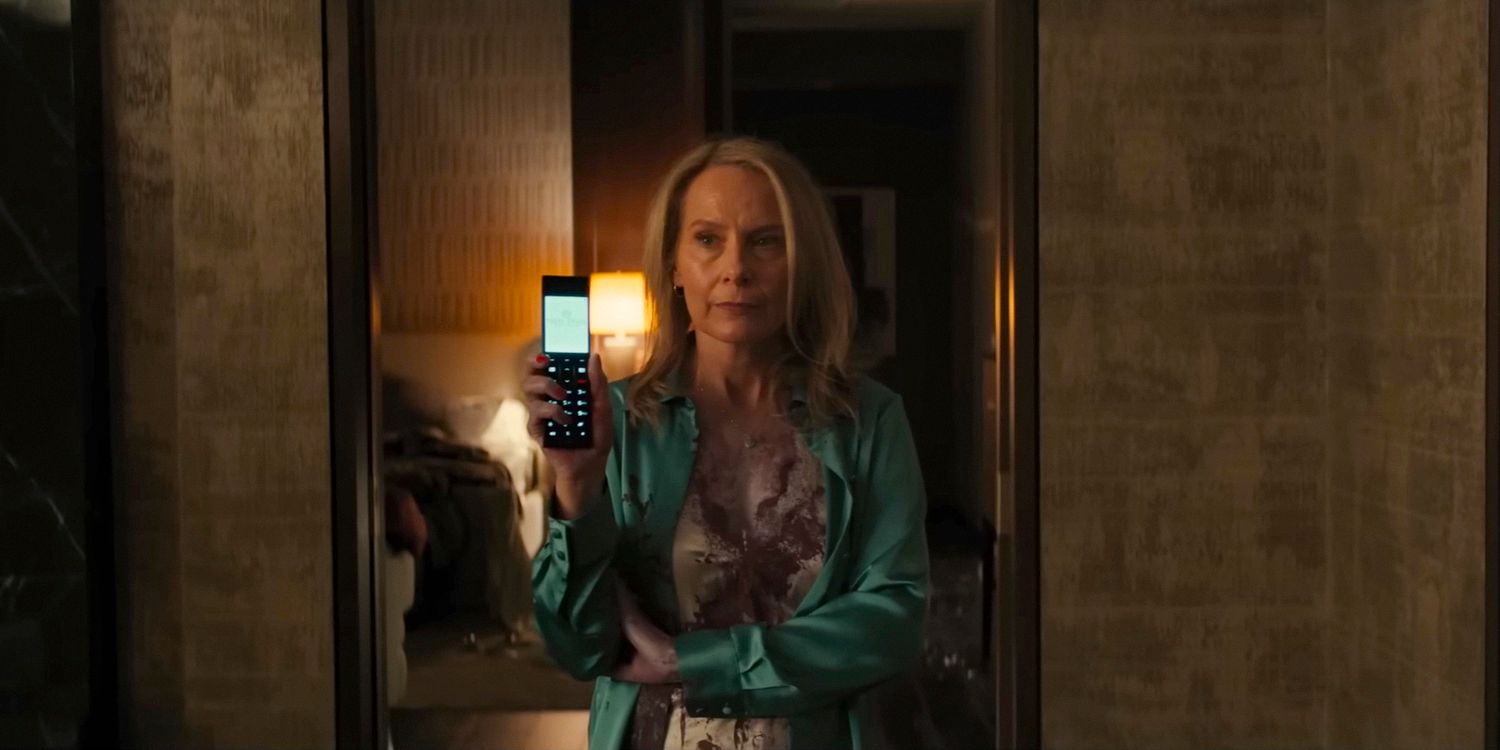 Margaret (Amy Ryan), with her arms crossed and looking annoyed, shows a phone in WOLFS