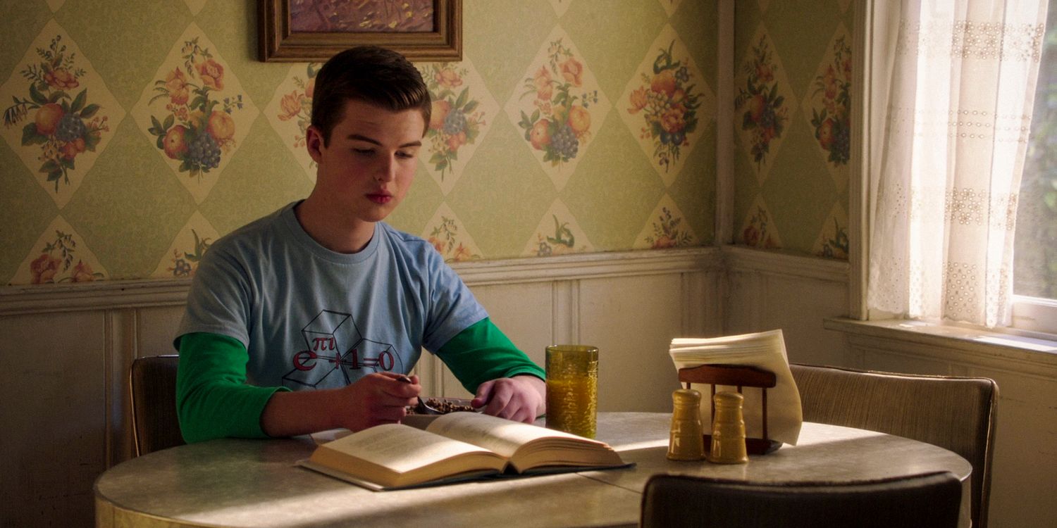 Sheldon (Iain Armitage) reading a book while having breakfast in Young Sheldon season 7 episode 12