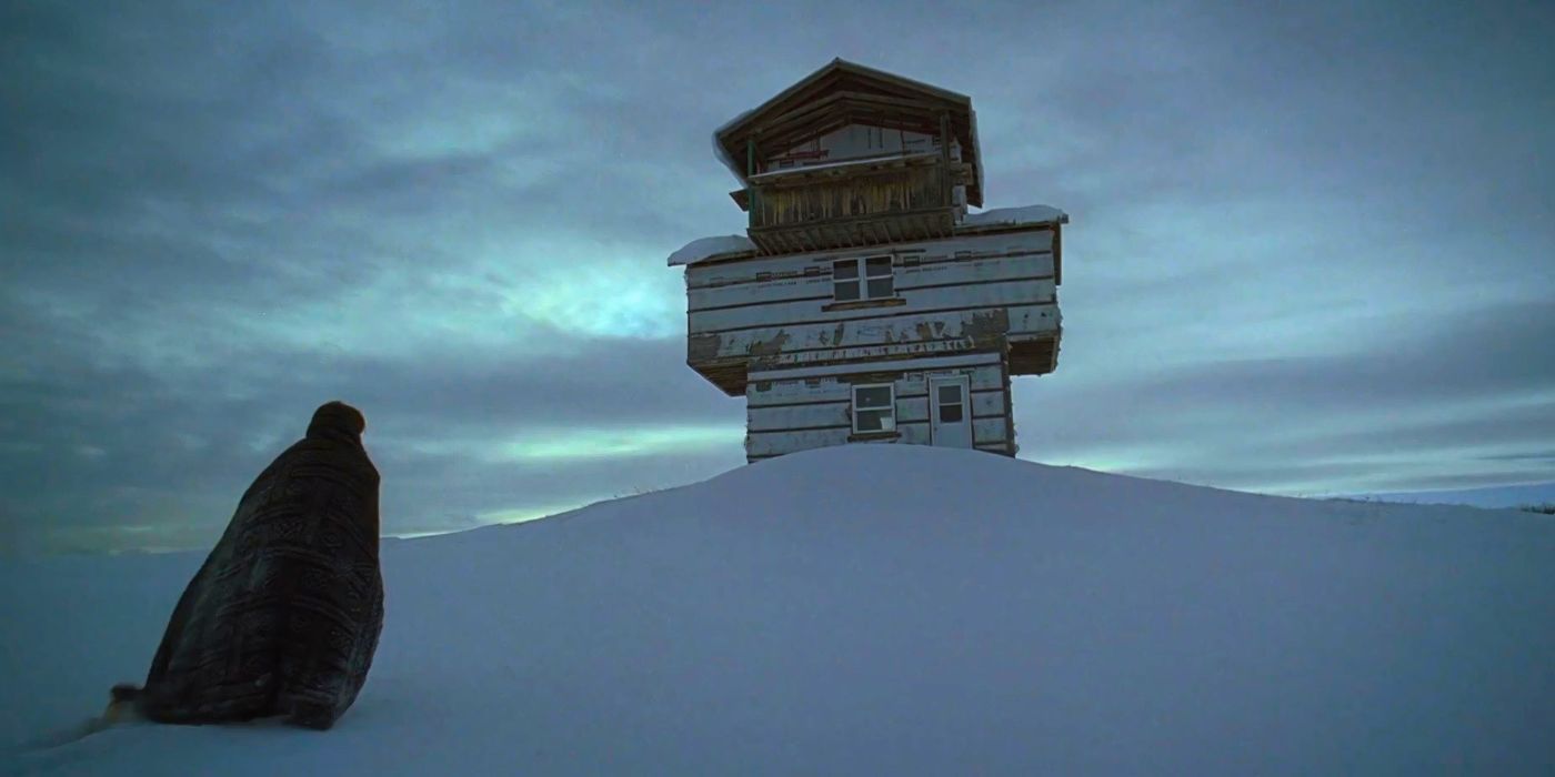 A figure walks toward a snow-covered lookout in The Lodge