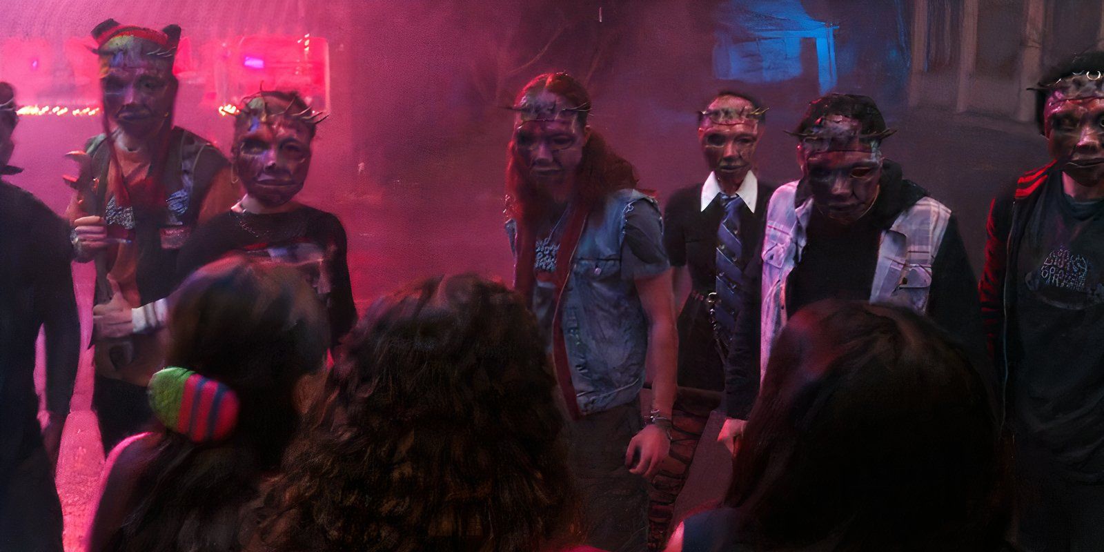 A mob of masked people stand in front of the Liars in Pretty Little Liars Summer School