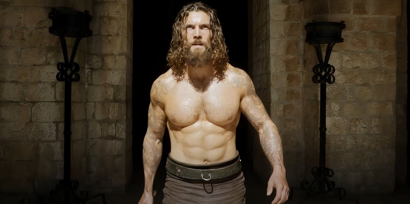 um homem sem camisa caminhando em direção à luz, saindo de uma porta forrada de pedra na terceira temporada de Vikings Valhalla