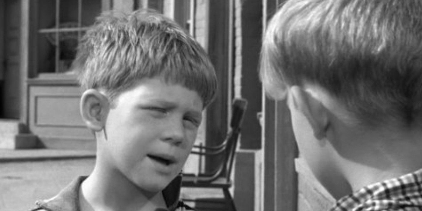 Andy Griffith show Ron Howard as Opie looking forward towards another boy with his eyes partially closed 