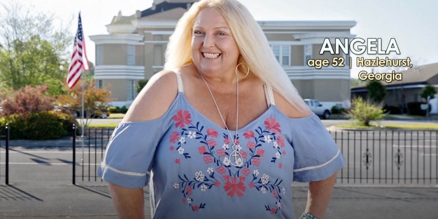 Angela Deem in 90 Day Fiance standing with hands on her hips in blue embroidered top smiling.
