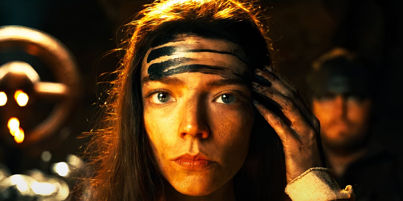 Anya Taylor-Joy smearing grease on her forehead as Furiosa in Furiosa A Mad Max Saga