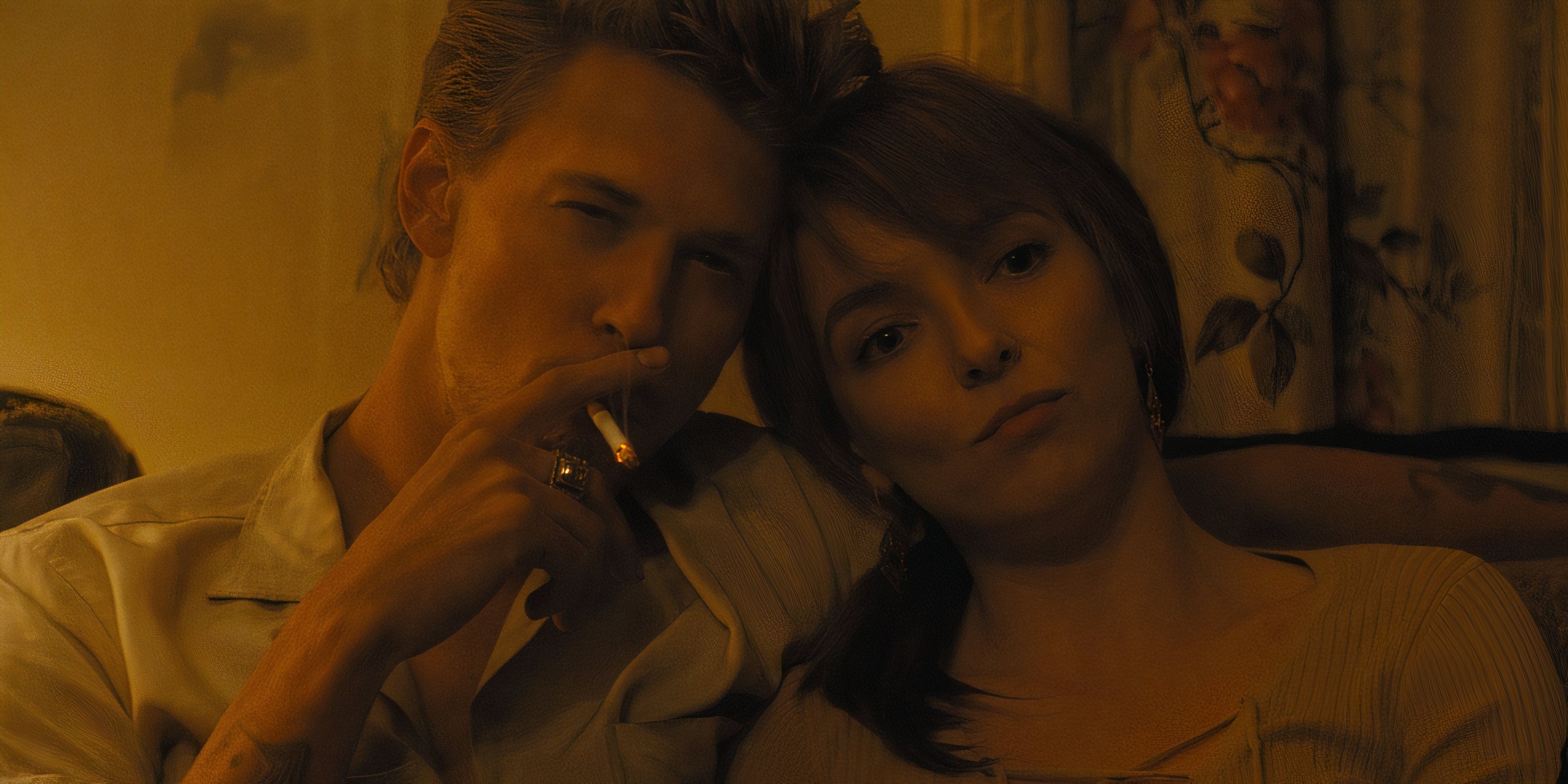 Austin Butler smokes and leans against Jodie Comer in The Bikeriders movie still