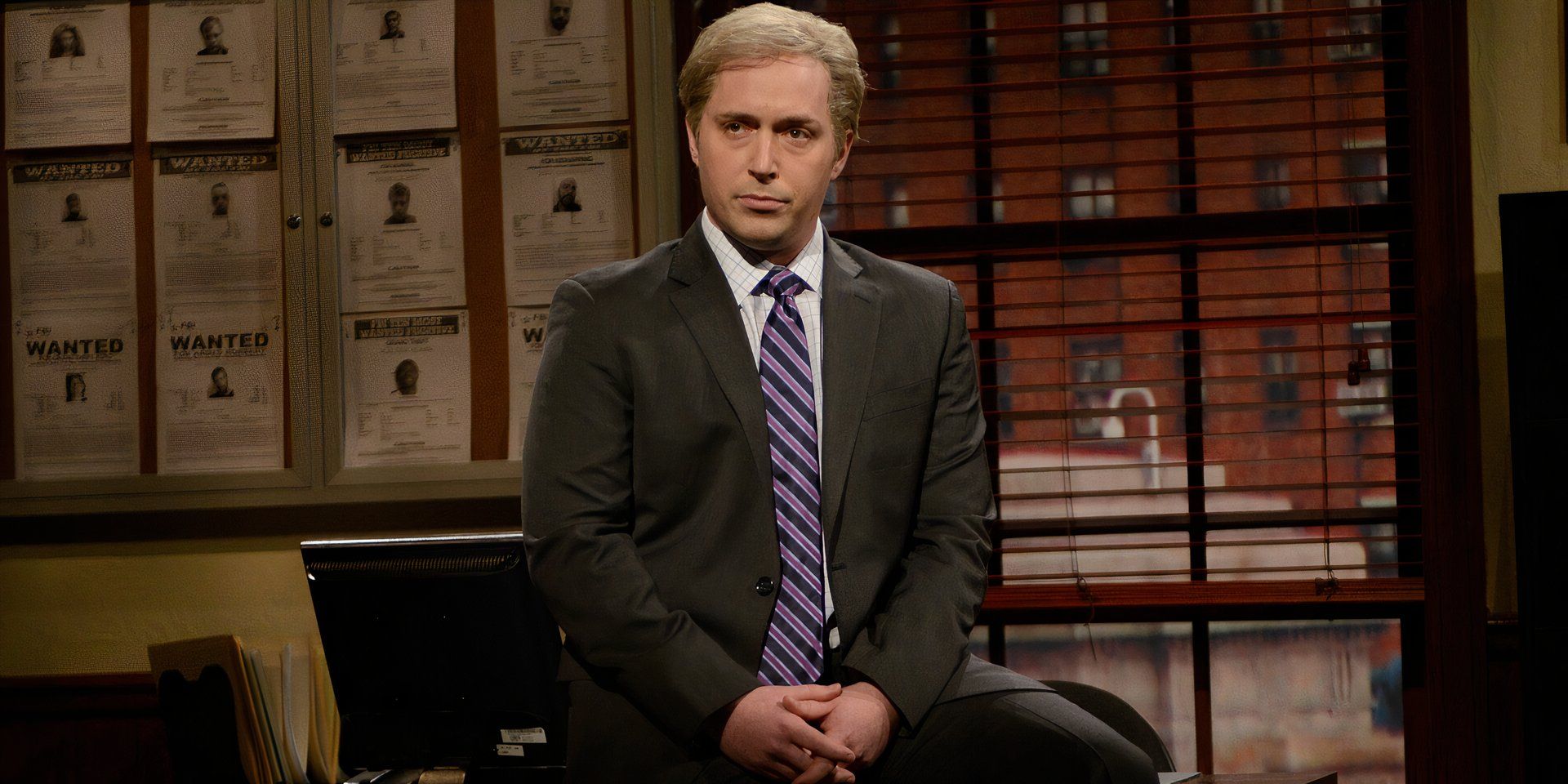 Beck Bennett in a Saturday Night Live sketch sat in a suit