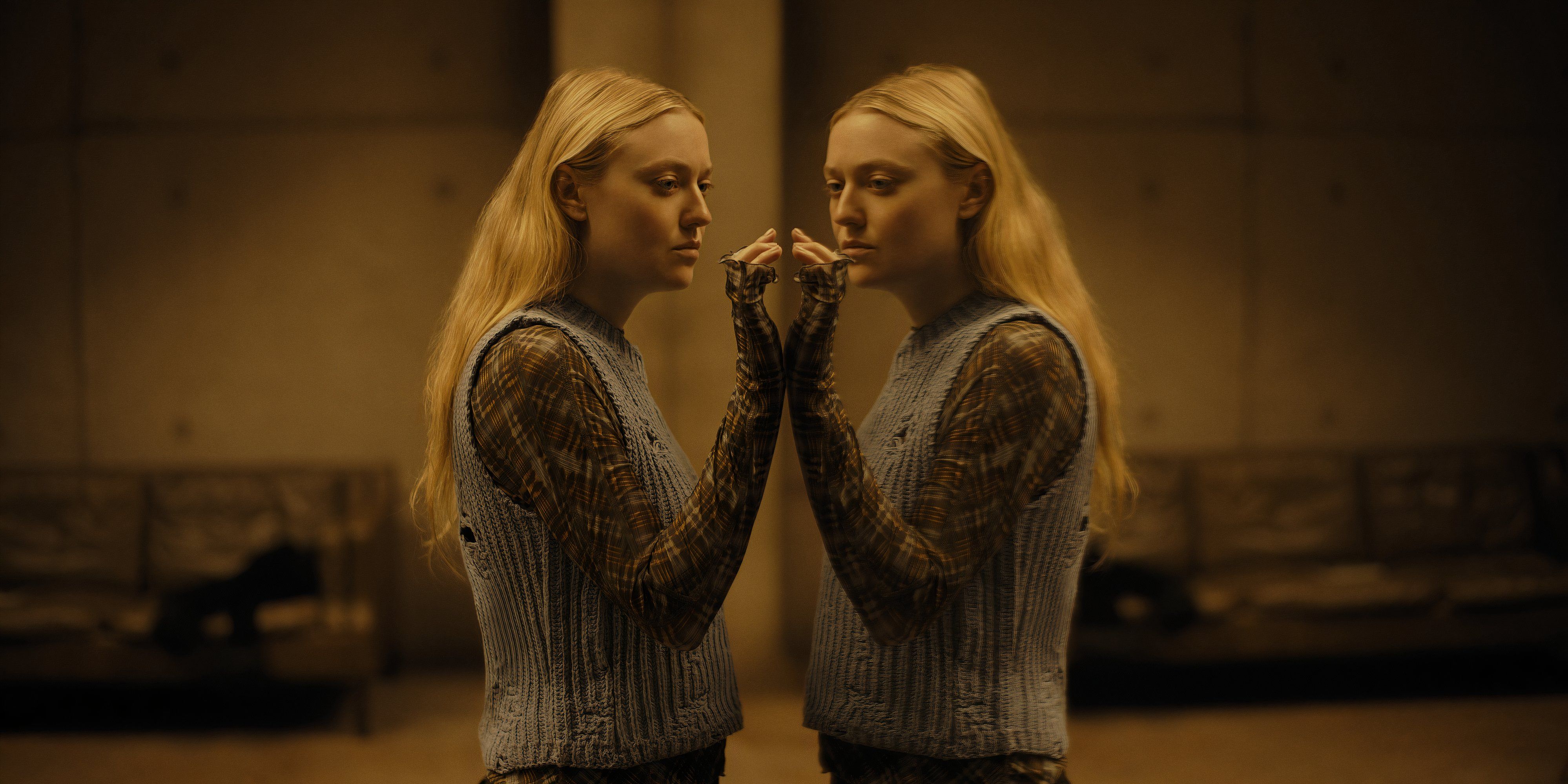 Dakota Fanning holds her hand up to mirror in The Watchers movie still