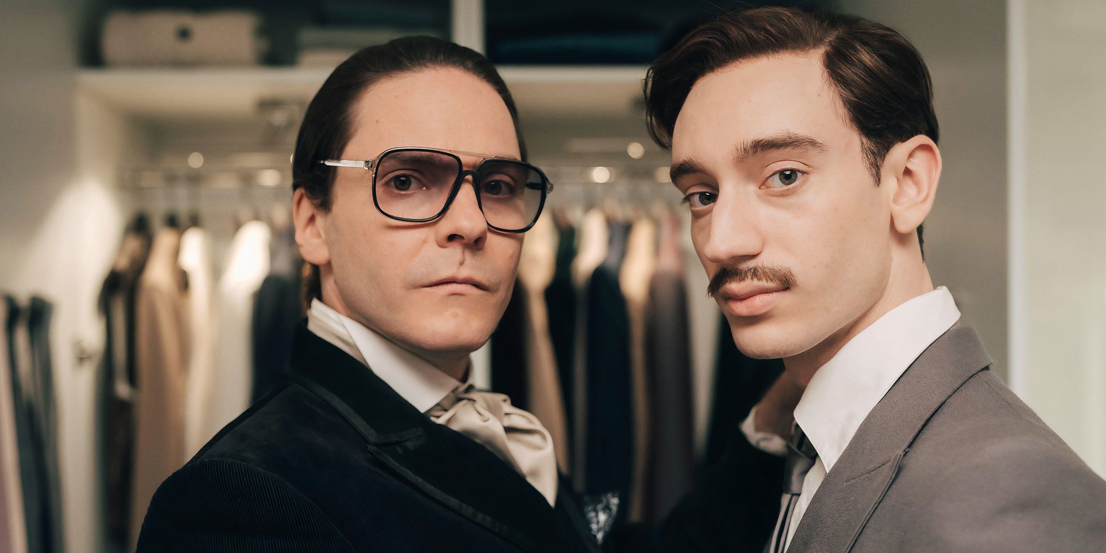 Daniel Brühl como Karl Lagerfeld e Théodore Pellerin como Jacques de Bascher em um alfaiate em Becoming Karl Lagerfeld