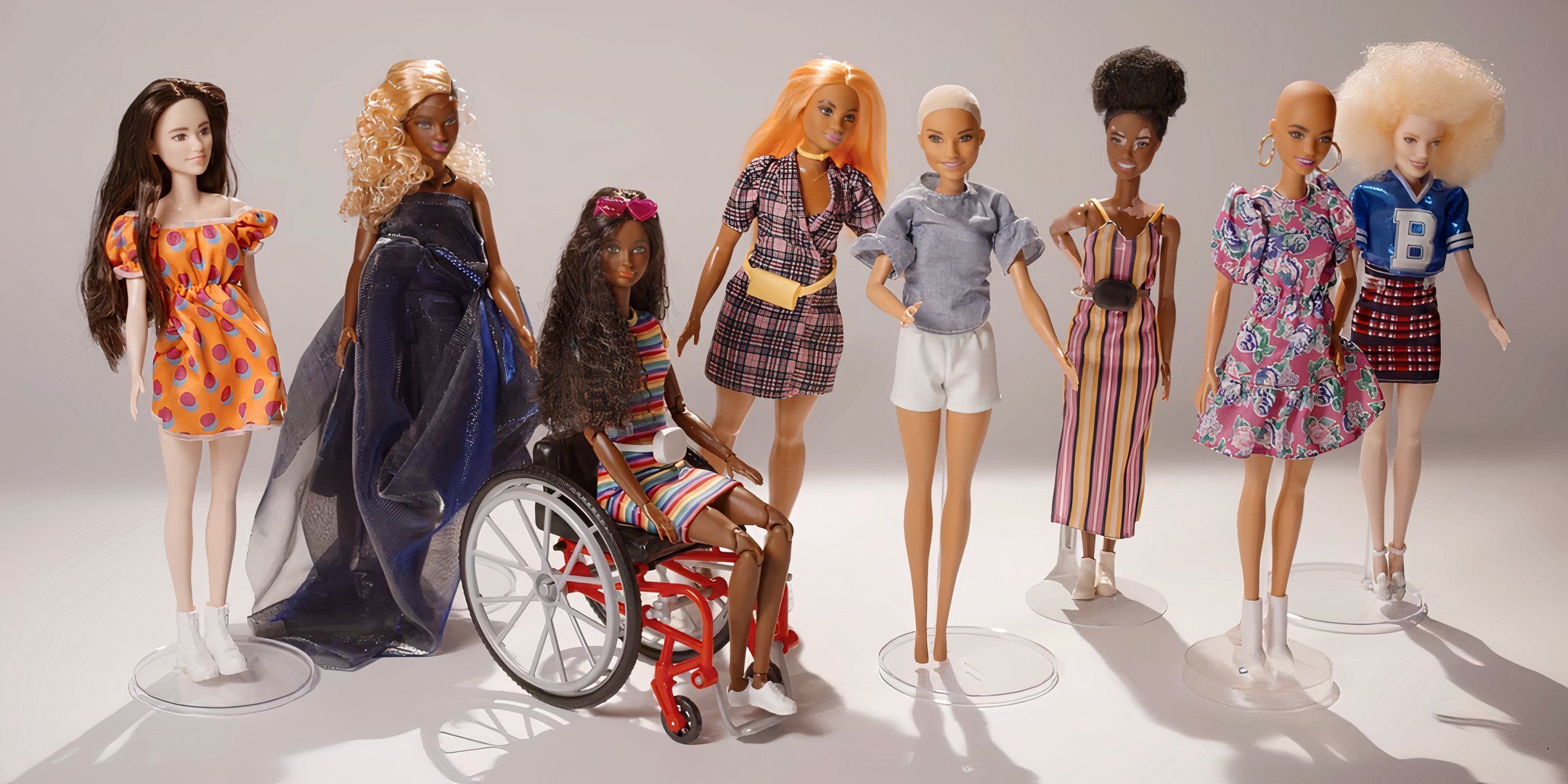 A line of diverse Barbie dolls are placed next to one another. 