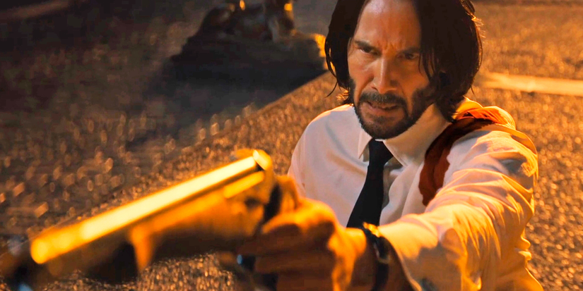 John Wick aims a pistol at someone offscreen in John Wick: Chapter 4