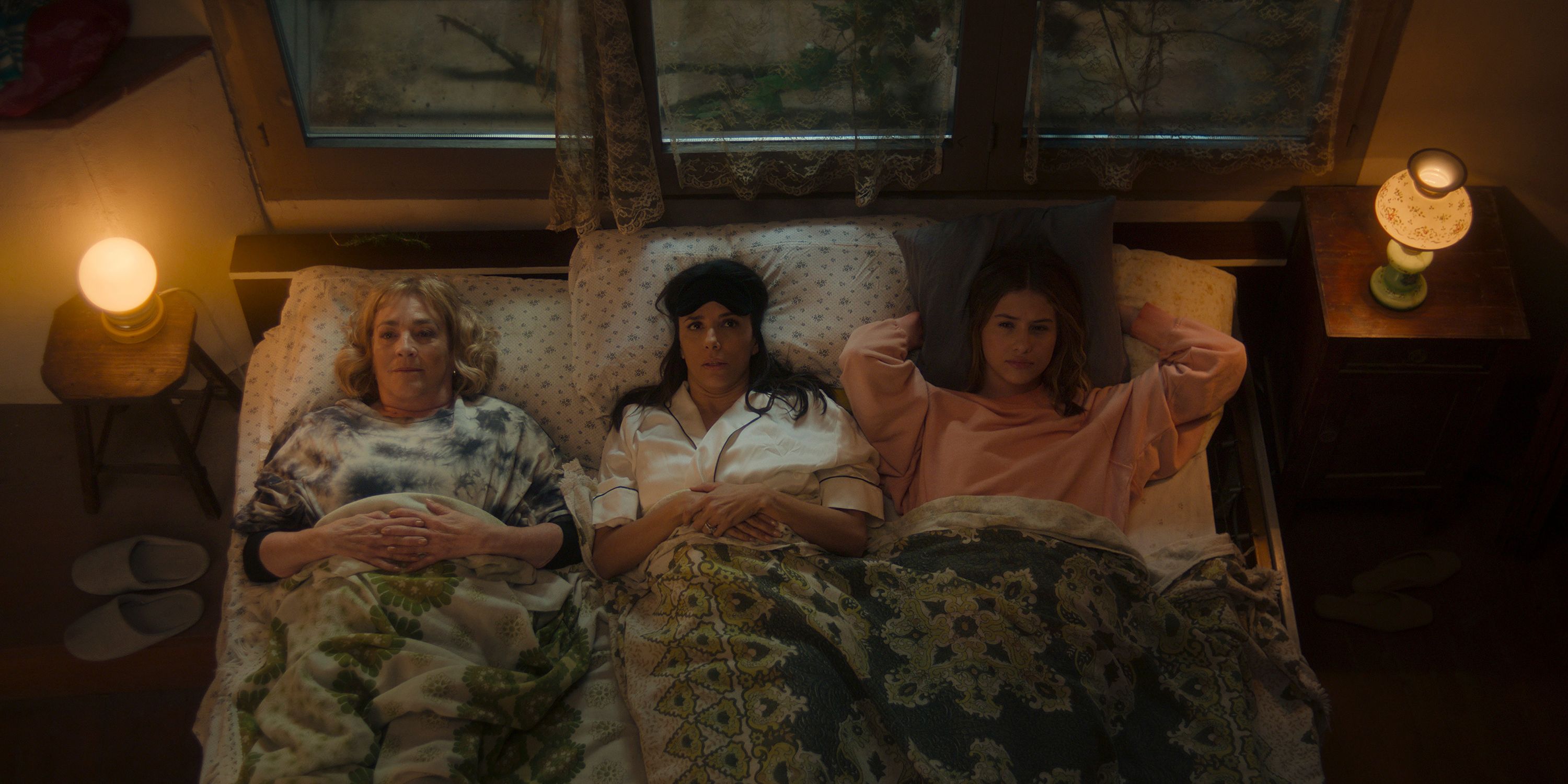 Gala, Julia e Kate deitadas na cama na Terra das Mulheres
