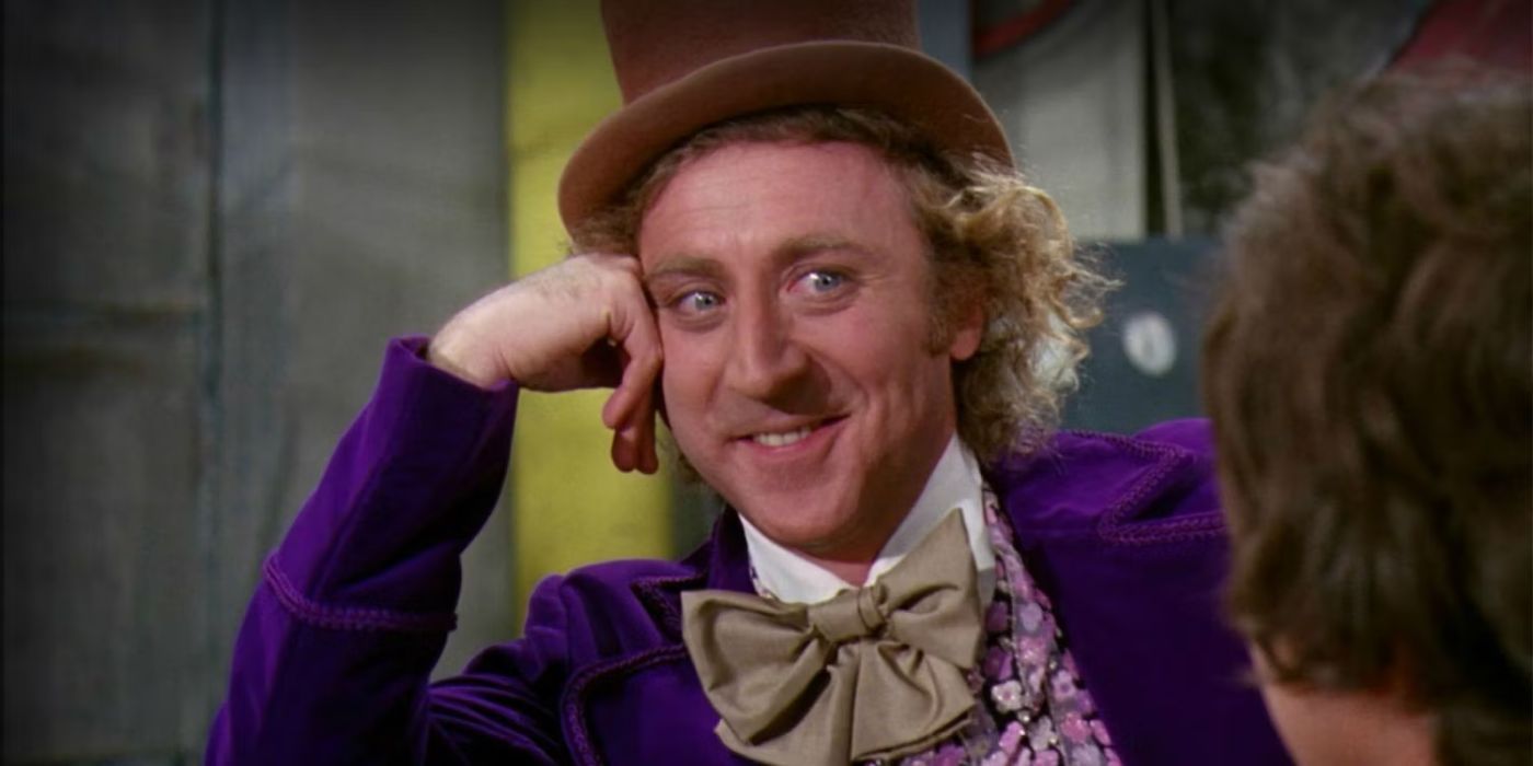 Gene Wilder como Willy Wonka pone su cabeza entre sus manos y sonríe.