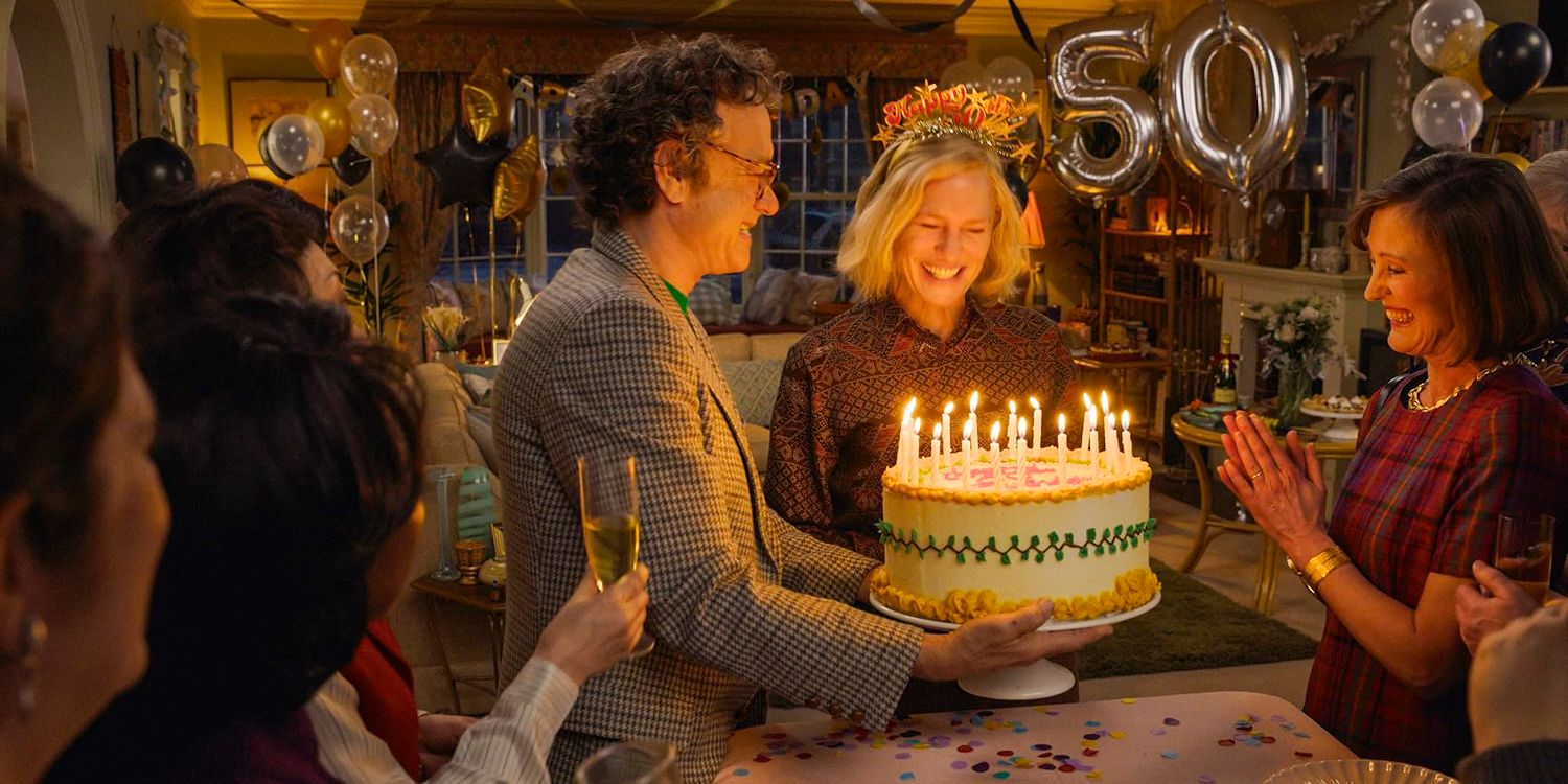 Tom Hanks sostiene un pastel para celebrar el 50 cumpleaños de Robin Wright aquí