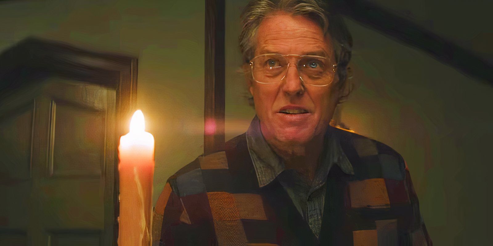 Hugh Grant holding a lit candle in Heretic