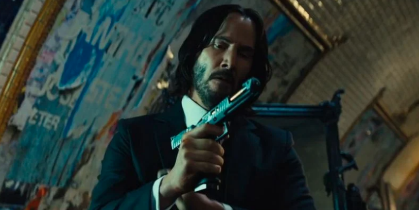 John Wick holds a gun in John Wick Chapter 4