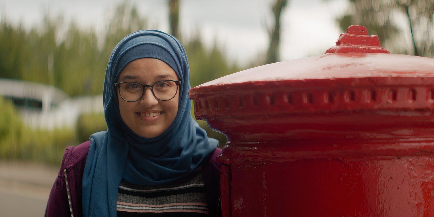 Lauren Patel lächelt, während sie in „Everybody's Talking About Jaime“ hinter dem Briefkasten steht