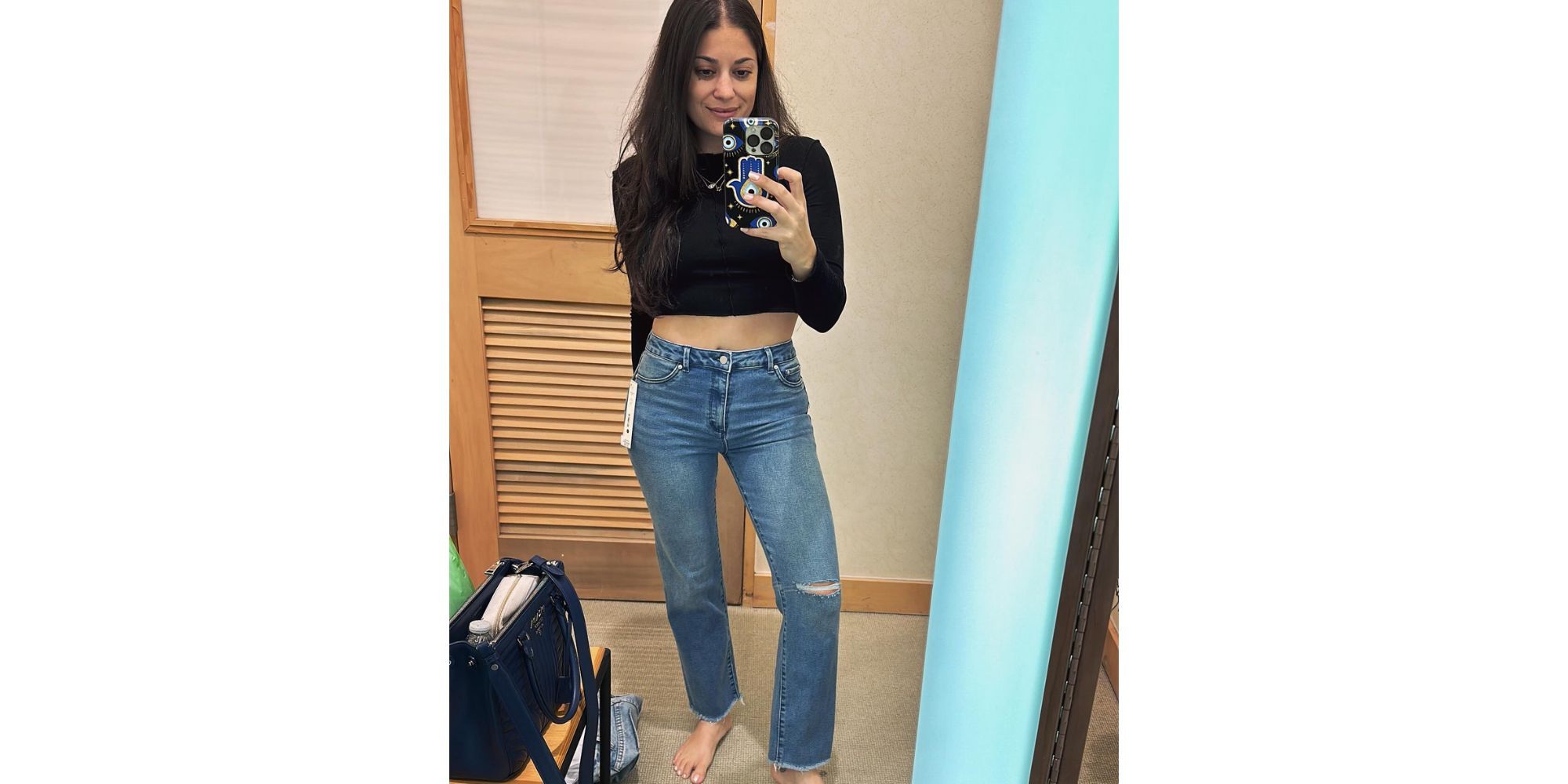 Loren Brovarnik In 90 Day Fiance clicking mirror selfie in fitting room wearing jeans and black crop top