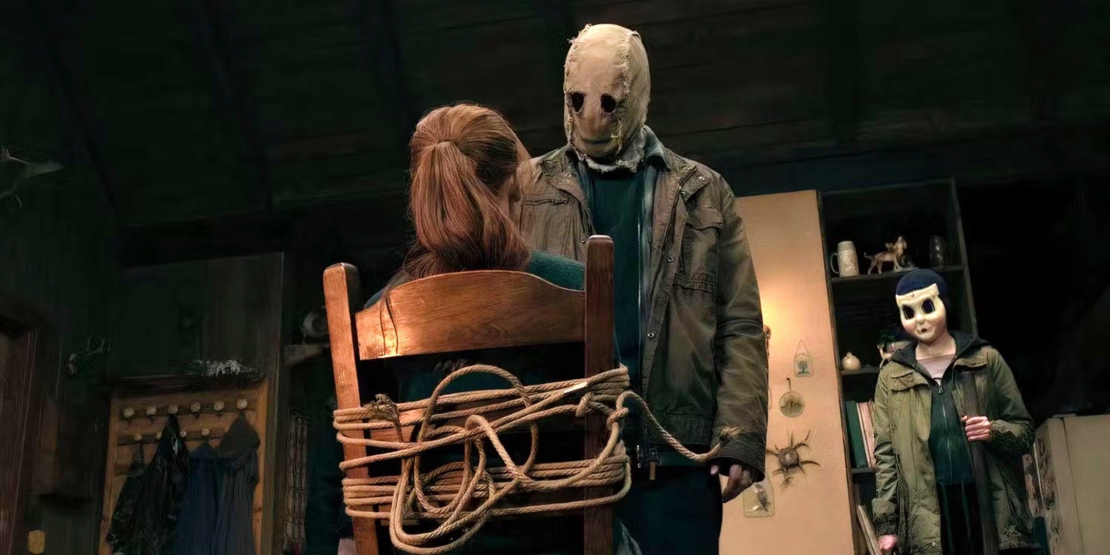 Madelaine Petsch as Maya tied up and helpless while facing a masked killer in The Strangers Chapter 1