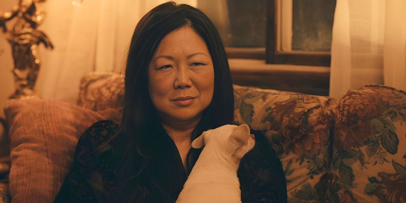 Margaret Cho looking serious with a dog in Cora Bora