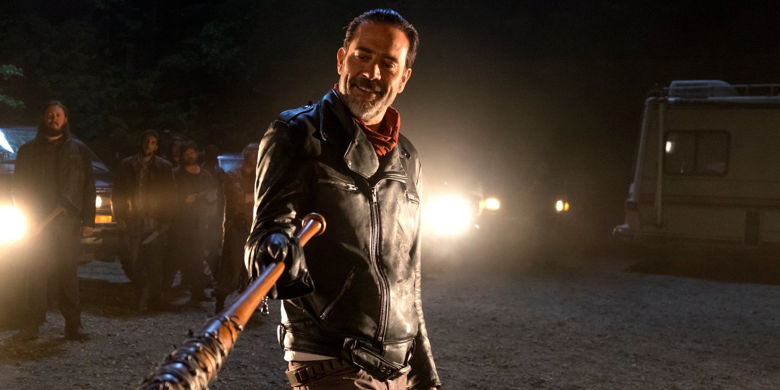 Negan com um sorriso malicioso, apontando seu taco de beisebol de arame farpado em The Walking Dead.