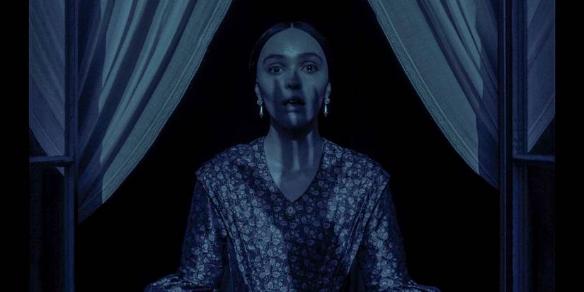 Ellen Hutter (Lily-Rose Depp) looking shocked with the shadow of a sinister hand cast upon her face in Nosferatu