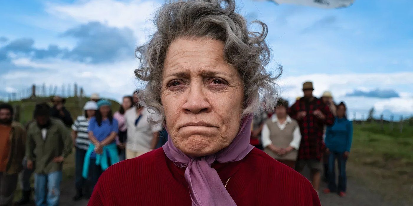 Rena Owen olha com uma carranca e um lenço roxo na cabeça