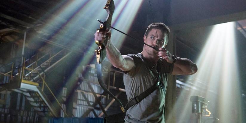 Stephen Amell as Oliver Queen aiming a bow in Arrow