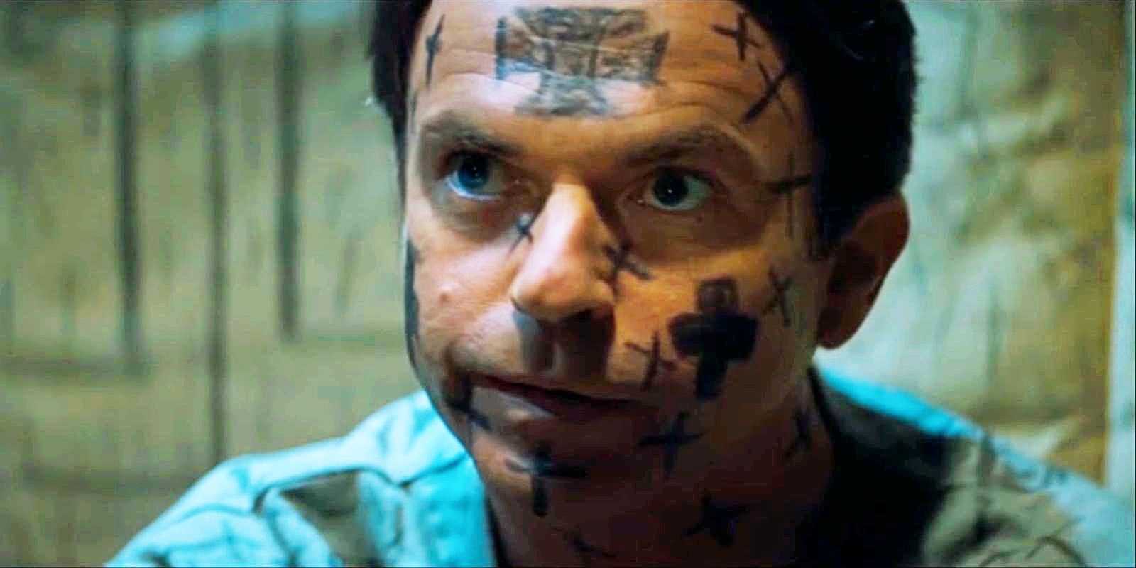 Sam Neill in an asylum with crosses drawn over his face in In The Mouth of Madness-1