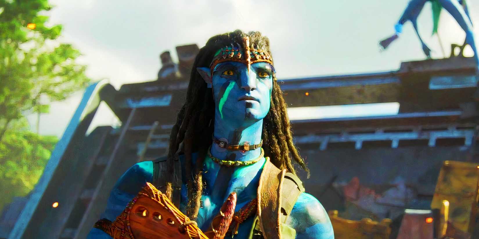 Sam Worthington as Jake Sully in war paint holding a rifle in Avatar The Way of Water