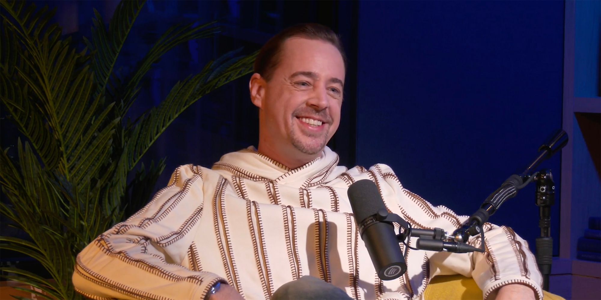 Sean Murray smiling in his chair with a microphone in front of him on Off Duty: An NCIS Rewatch