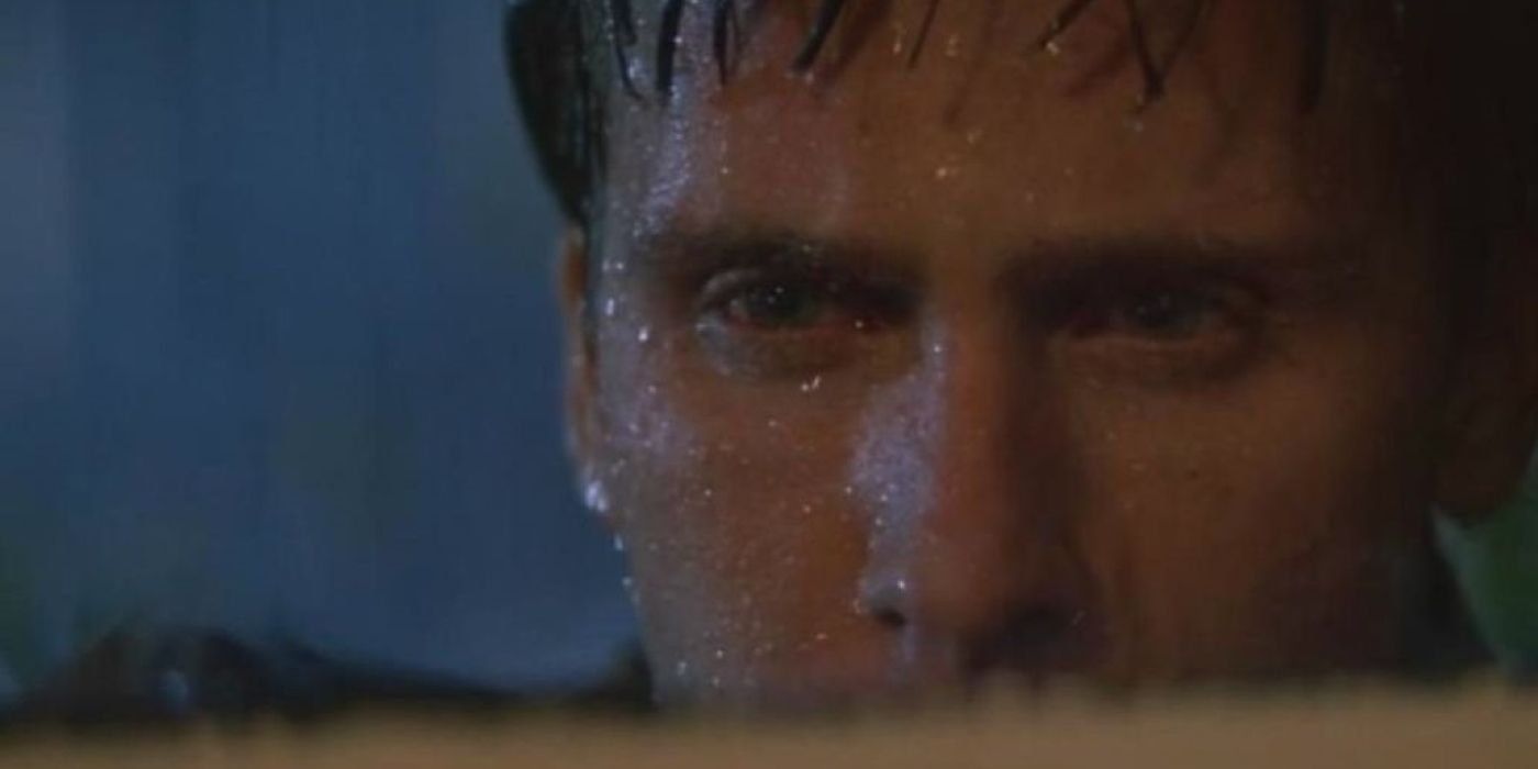 Emilio Estevez como Kirby parado na chuva olhando intensamente para o fogo de Santo Elmo