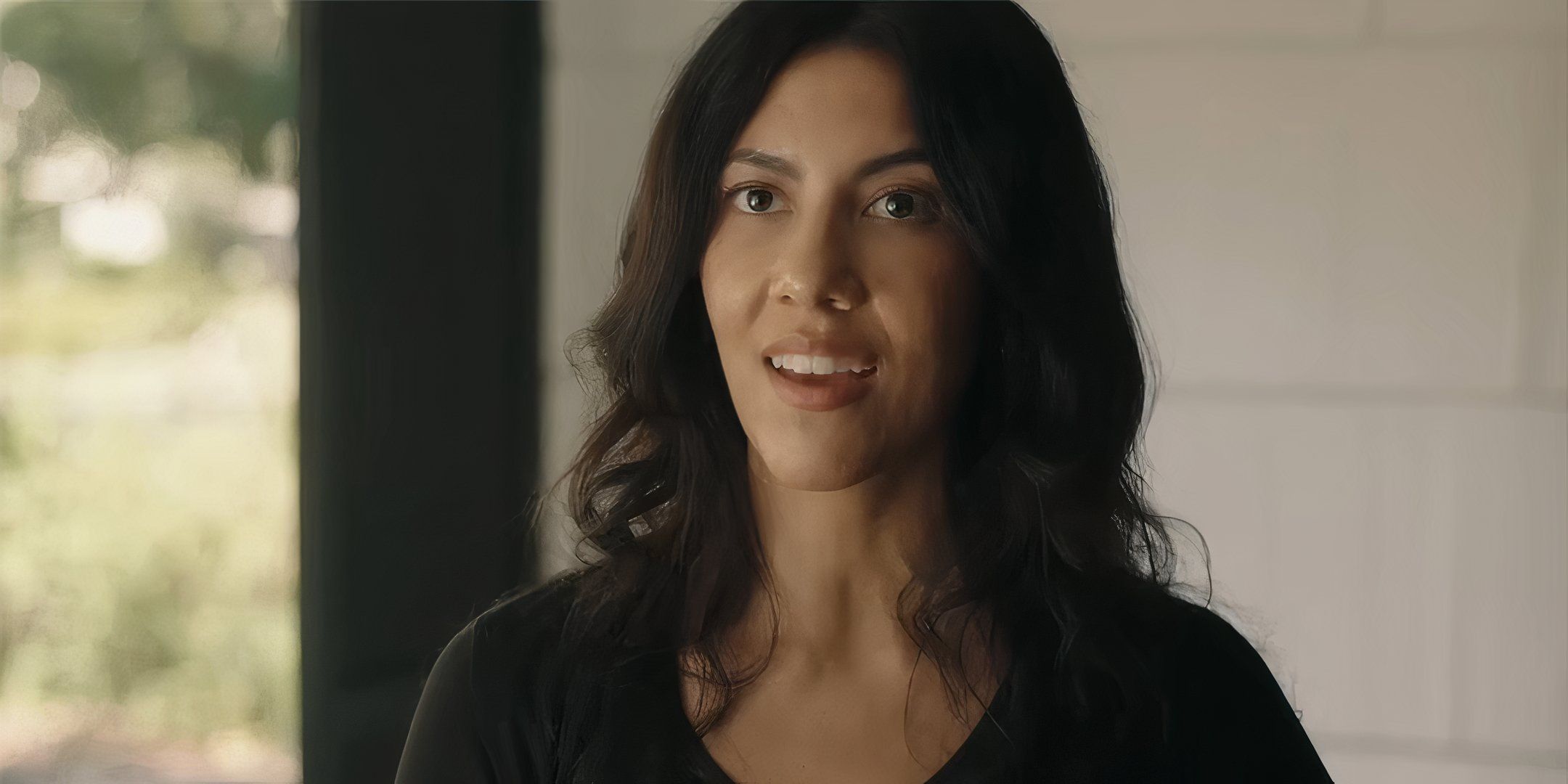 Stephanie Beatriz as Mariana looking happy while talking to Ted in Reverse the Curse