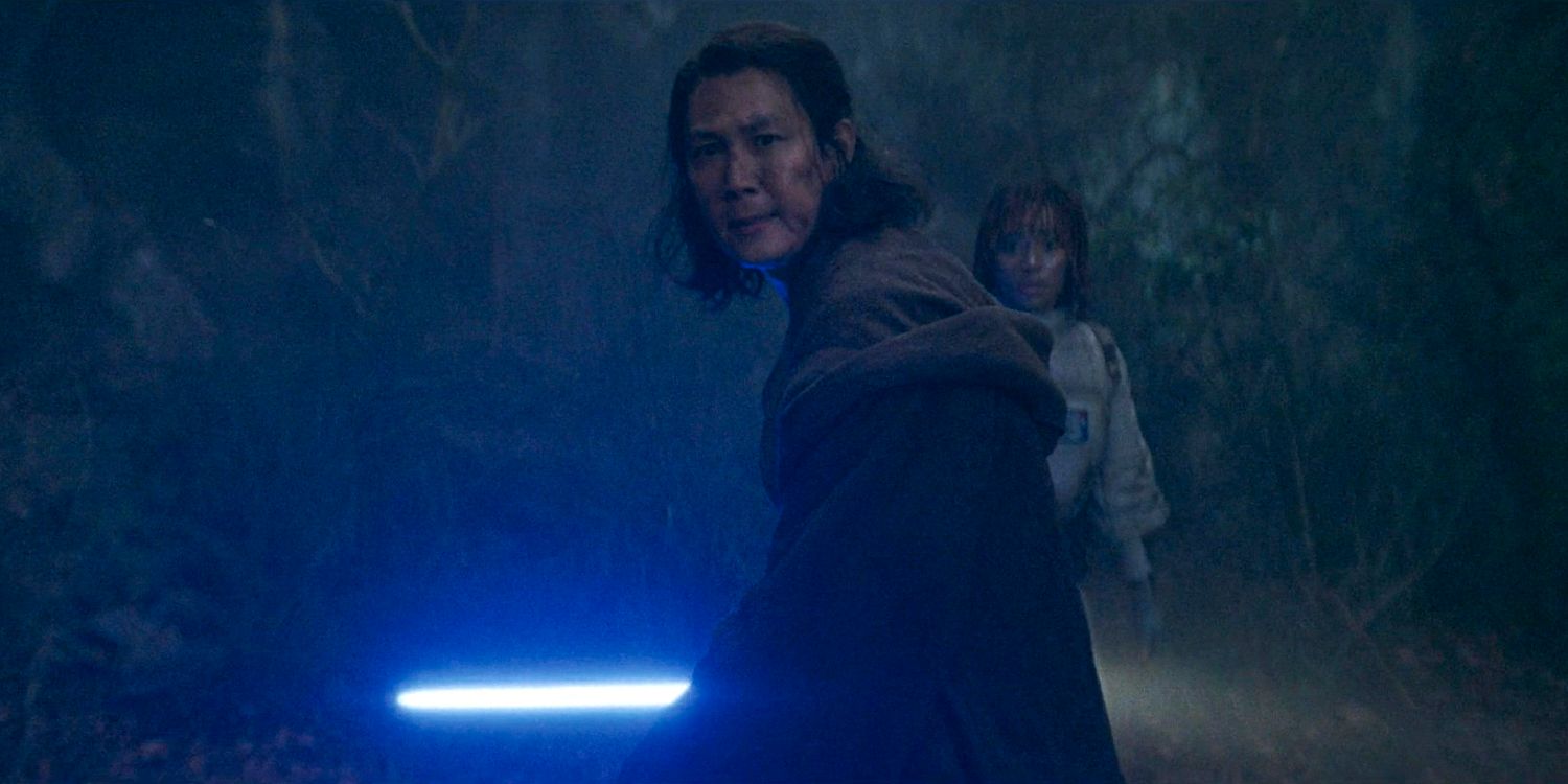 Master Sol (Lee Jung-jae) wielding his lightsaber to protect Osha (Amandla Stenberg) from the Sith in The Acolyte season 1 episode 5