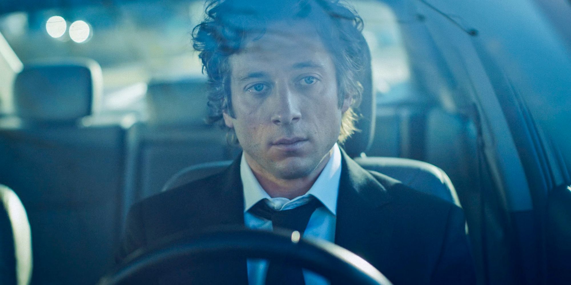 In a car, Carmy (Jeremy Allen White) watches the funeral of Michael from a distance in The Bear Season 3 Episode 1