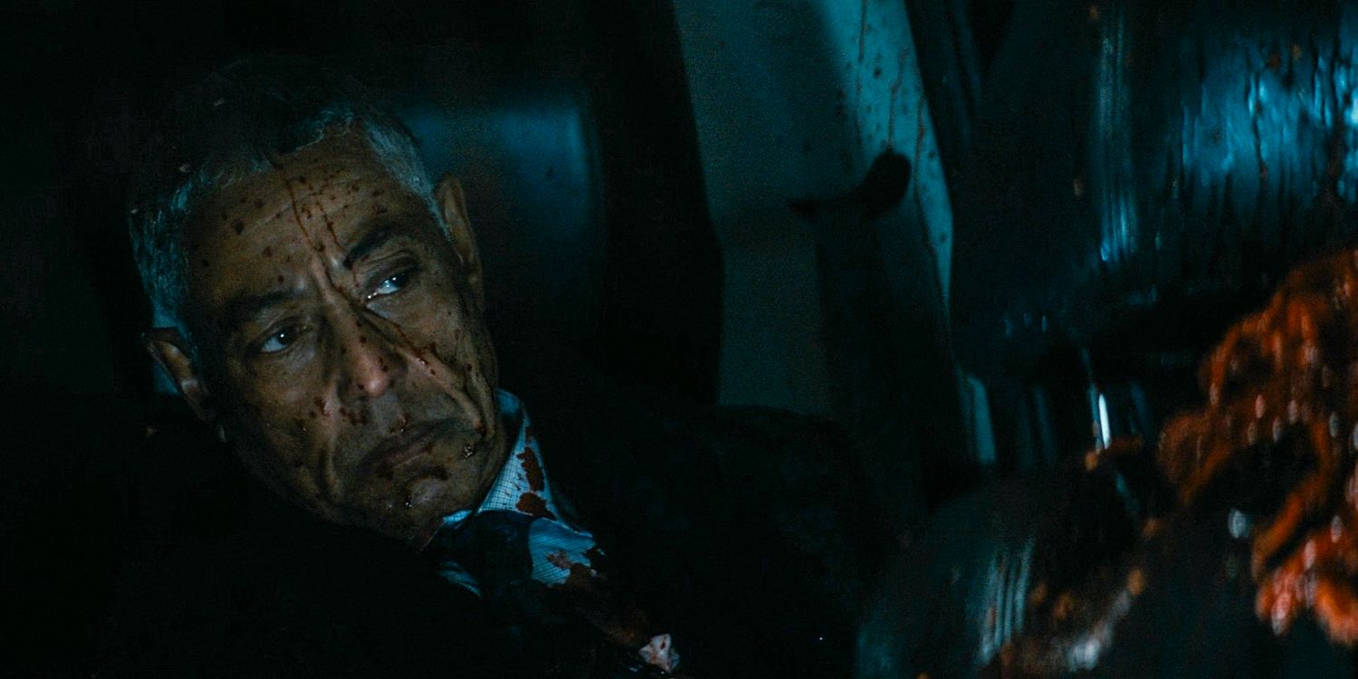 Em um carro, Stan Edgar (Giancarlo Esposito) com o rosto respingado de sangue no episódio 5 da 4ª temporada de The Boys