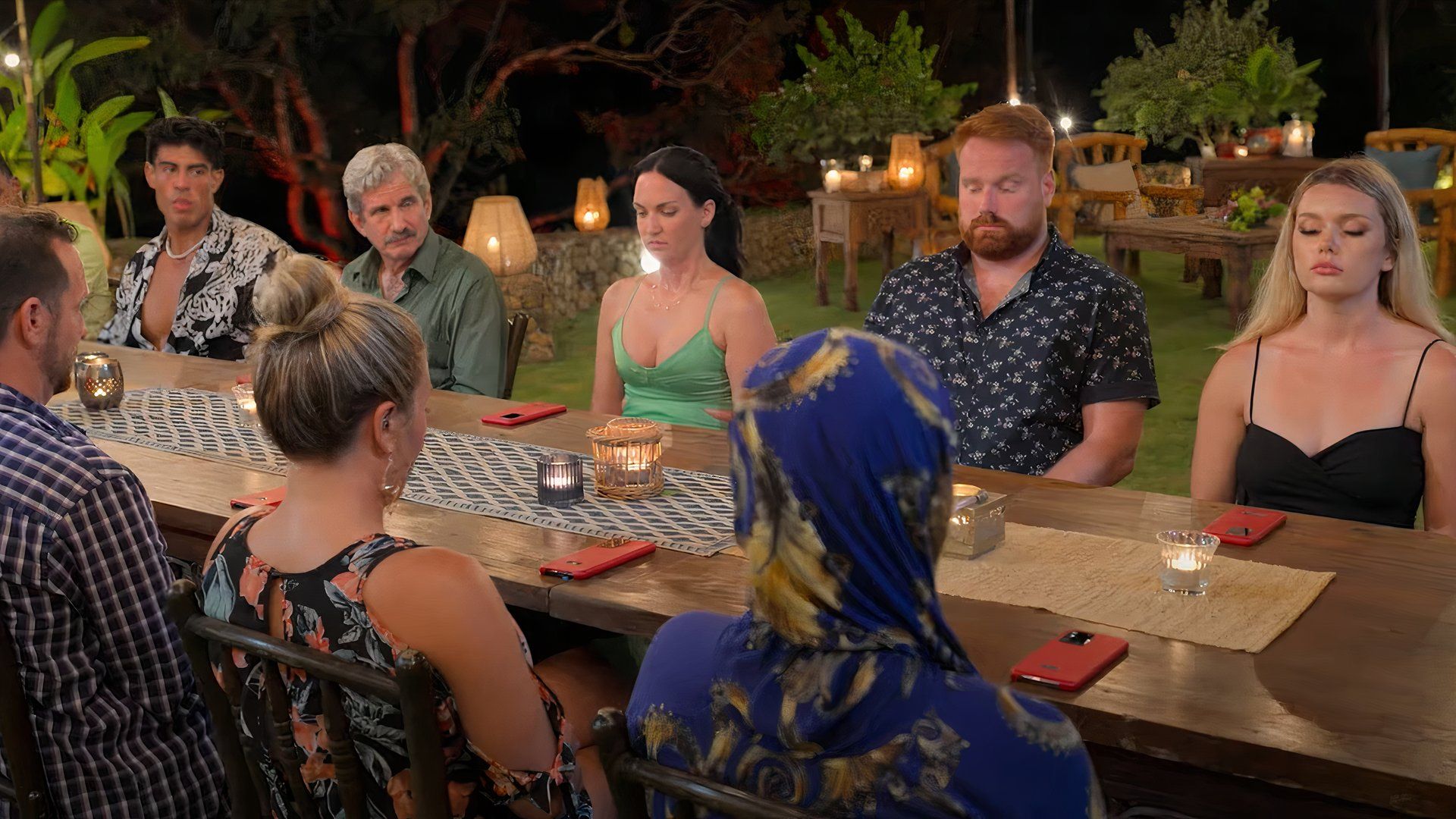 The Mole Season 2 trailer screenshot shows the contestants sitting at a table.